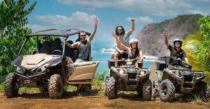 Group of travelers posing with ATVs and a UTV at a scenic coastal viewpoint near Jaco, Costa Rica, with the Pacific Ocean in the background.