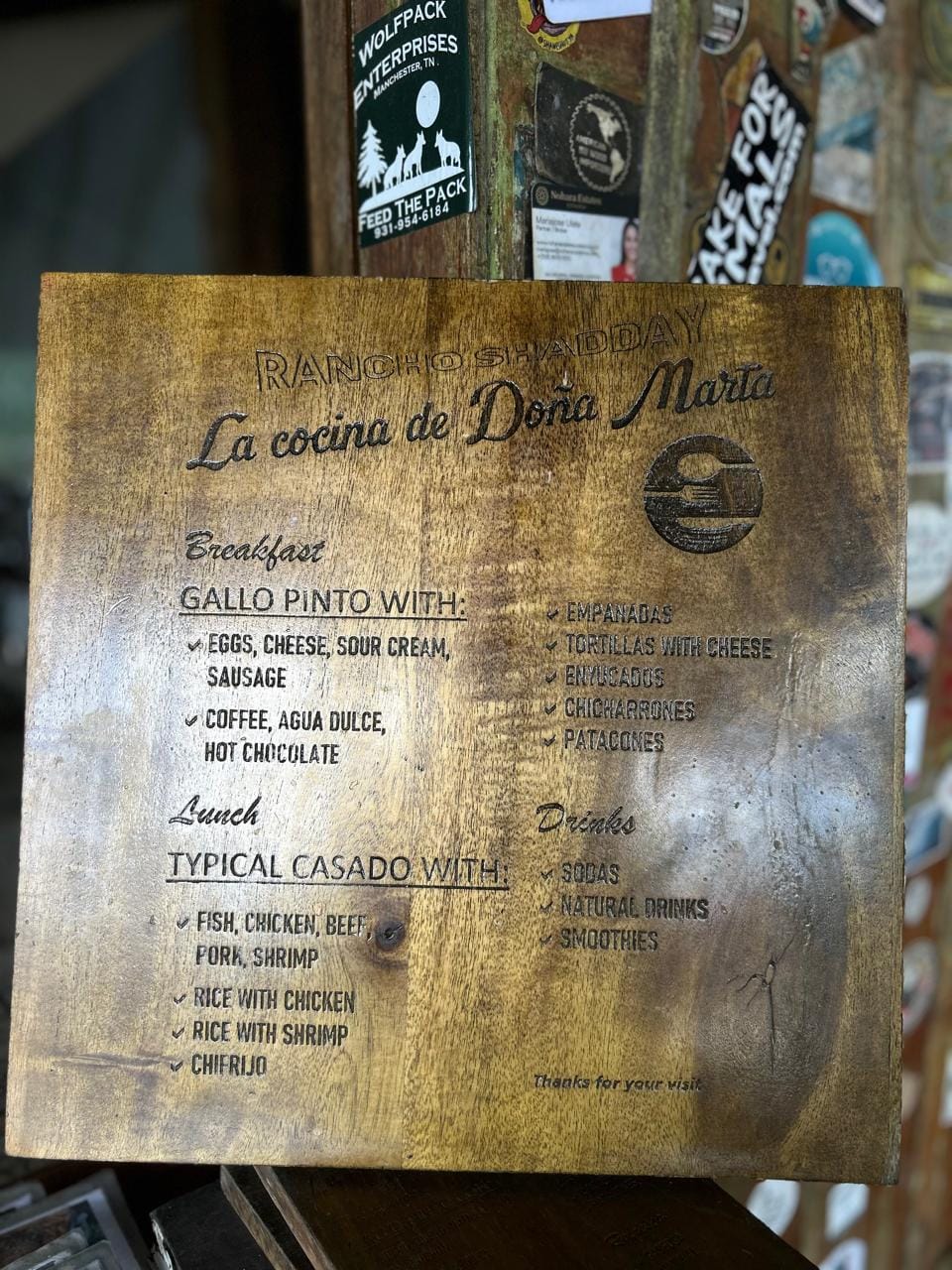 Close-up of the wooden menu board at Doña Marta’s mountain restaurant near Jaco, Costa Rica, listing traditional dishes like casado, gallo pinto, and empanadas.