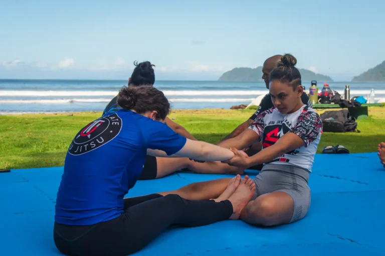 Women practicing Jiu Jitsu drills outdoors with ocean view in Jaco Costa Rica