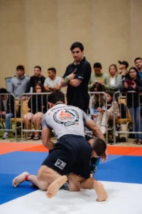 Jiu Jitsu match with athlete maintaining dominant position on the mats