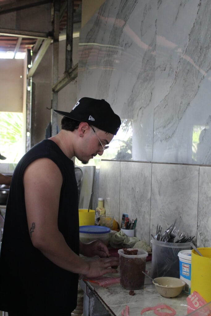 Guest preparing fresh tortillas in the kitchen at Doña Marta’s mountain restaurant near Jaco, Costa Rica during a cultural food tour.