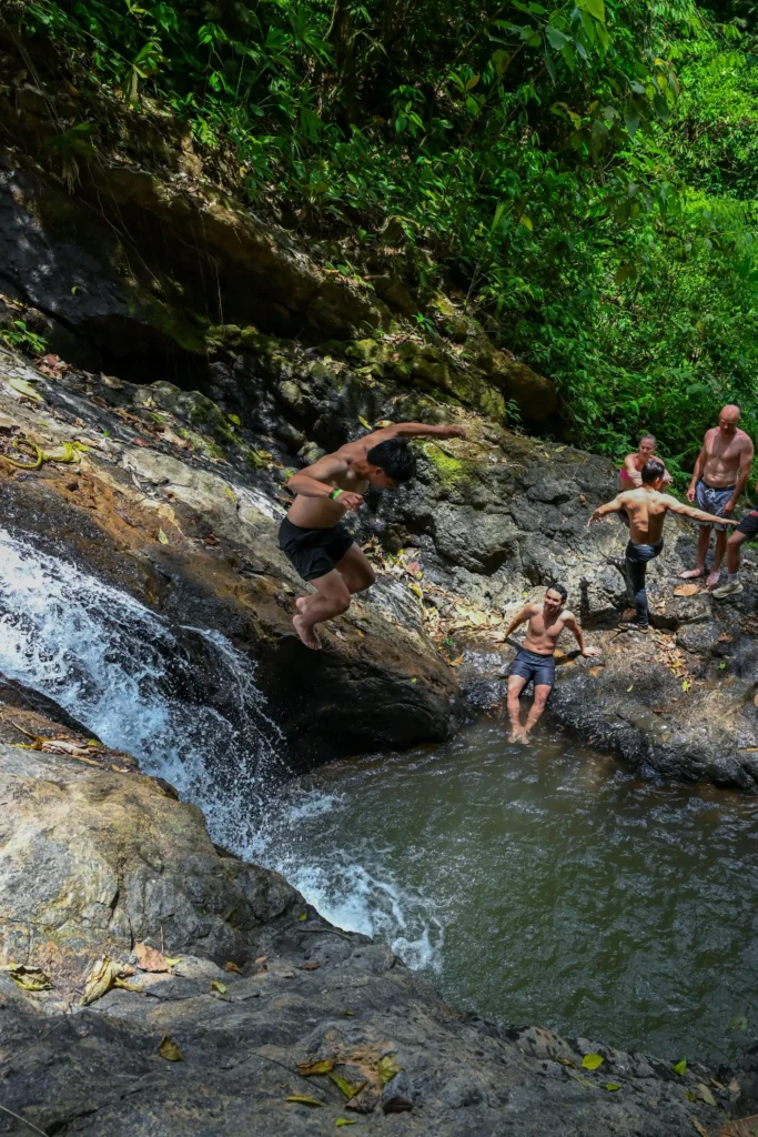 Traveler jumping into a natural pool during a Jaco waterfall tour in Costa Rica