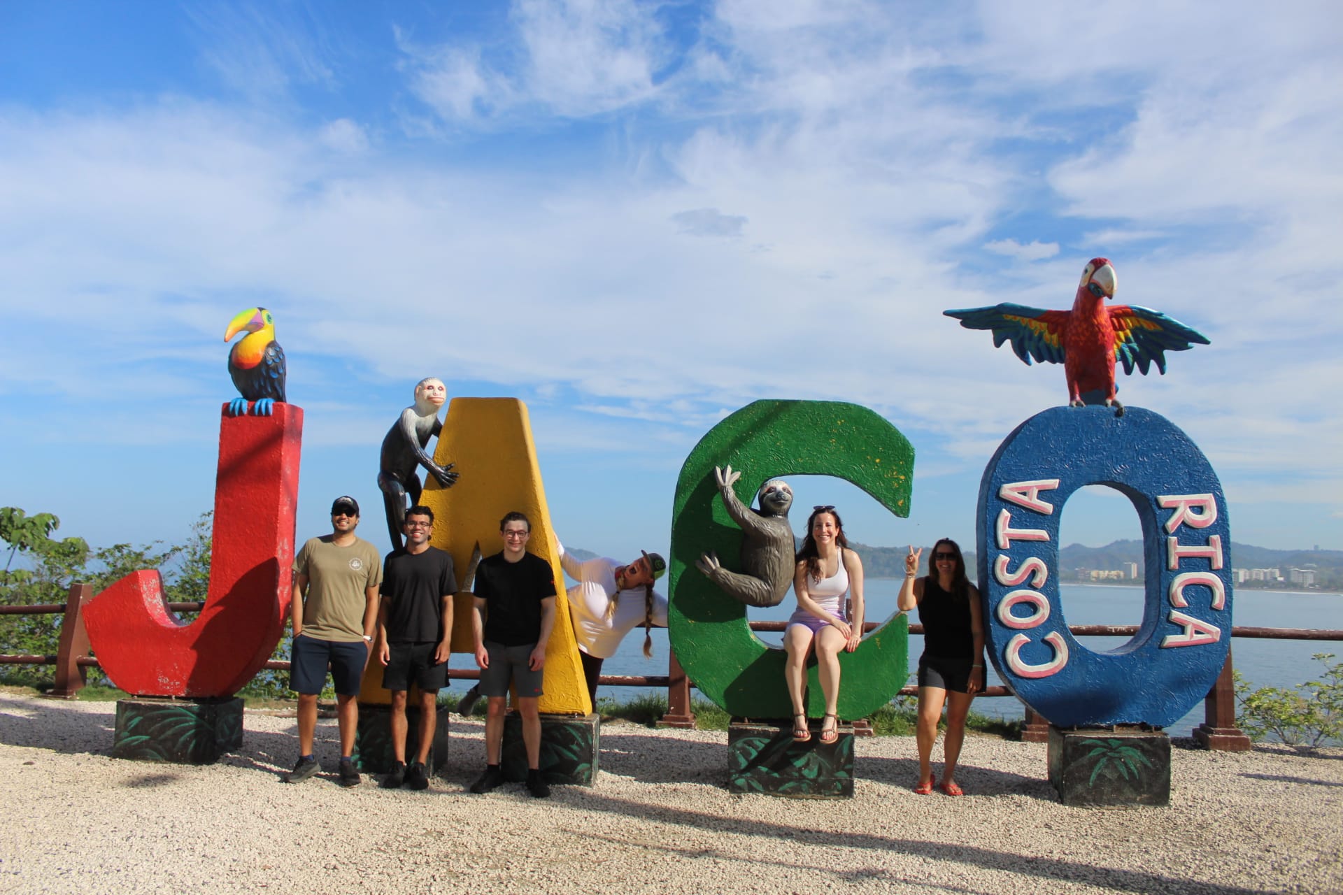 Group of travelers posing at the Jaco Costa Rica sign before their adventure