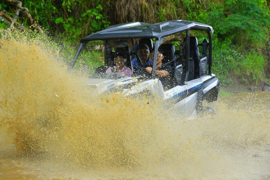 ATV splashing through a muddy rainforest trail near Jaco, Costa Rica