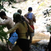 Travelers crossing a stream during a guided Jaco Waterfall Tour