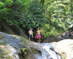 Travelers exploring the rock formations at Jaco Falls