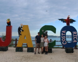 Family posing at the Jaco Costa Rica sign before their adventure