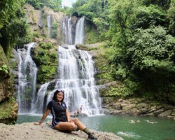 Guest posing in front of Nauyaca Waterfalls in Costa Rica