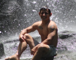 Guest relaxing beneath the falls at Nauyaca Waterfalls