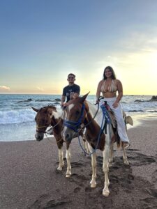 Travelers horseback riding along the beach near Jaco, Costa Rica