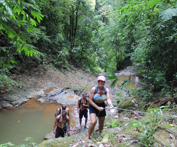 Group hiking through a river during a Jaco Waterfalls Tour in Costa Rica